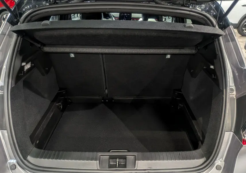 Coffre ouvert vu de l'arrière d'un Renault Captur TCe 160 gris Cassiopé avec toit noir, intérieur noir spacieux et propre.