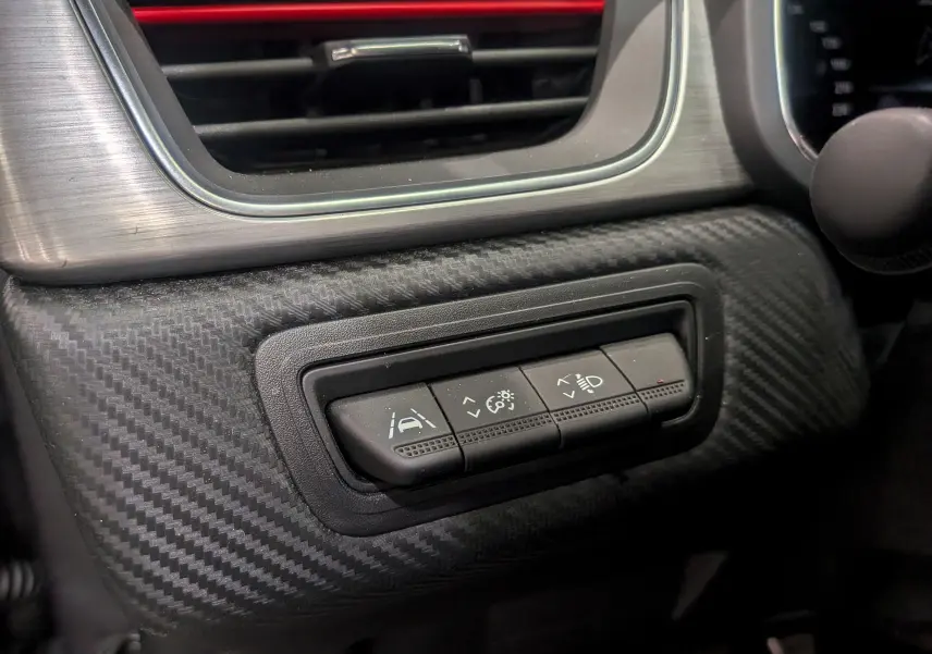 Gros plan sur les commandes d'assistance à la conduite du tableau de bord en carbone du Renault Captur TCe 160 R.S. Line 2022.