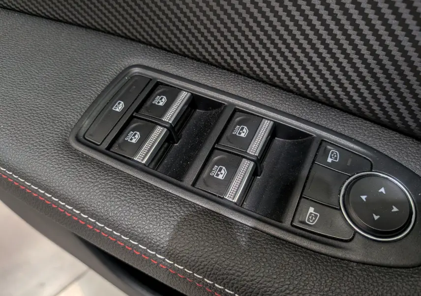 Gros plan sur les commandes des vitres électriques et réglages des rétroviseurs du Renault Captur TCe 160 R.S. Line 2022.
