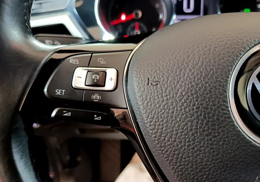 Gros plan sur le volant cuir gris du Volkswagen Touran 2021 avec commandes intégrées au côté gauche.