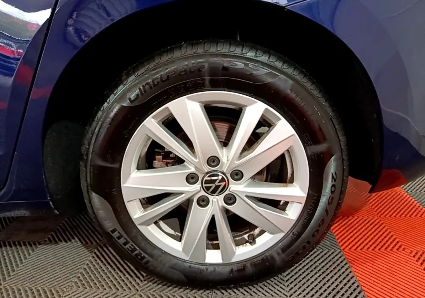 Gros plan sur la roue avant gauche du Volkswagen Touran bleu 2021, mettant en valeur la jante alliage et le pneu Pirelli.