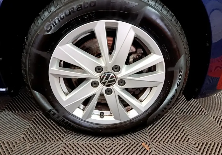 Gros plan sur la roue avant droite bleu d’un Volkswagen Touran 1.5 TSI EVO DSG7 United avec jante alliage argentée.