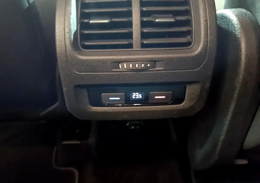 Vue rapprochée des commandes de climatisation arrière noires du Volkswagen Touran bleu 2021, affichant 23,5°C.