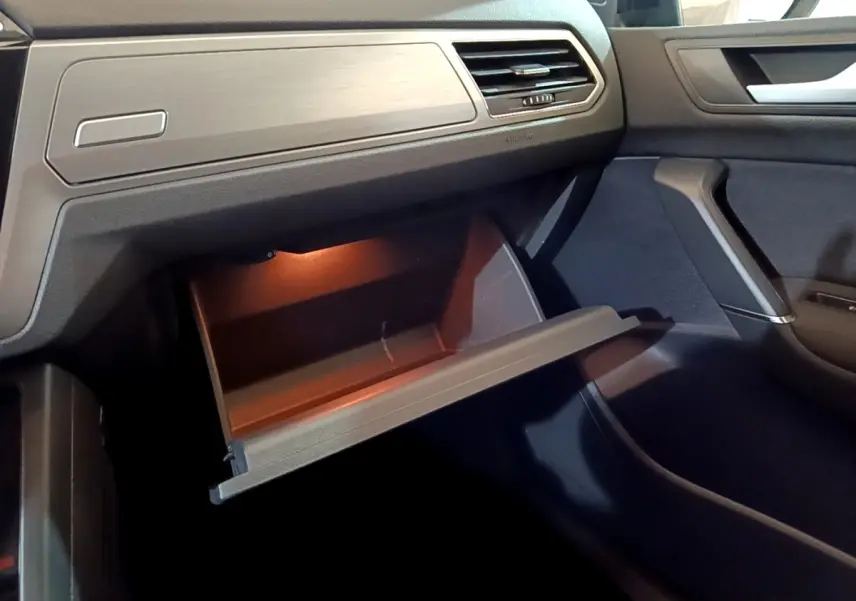 Intérieur du Volkswagen Touran 1.5 TSI EVO DSG7 United 2021, vue côté passager sur boîte à gants ouverte éclairée.
