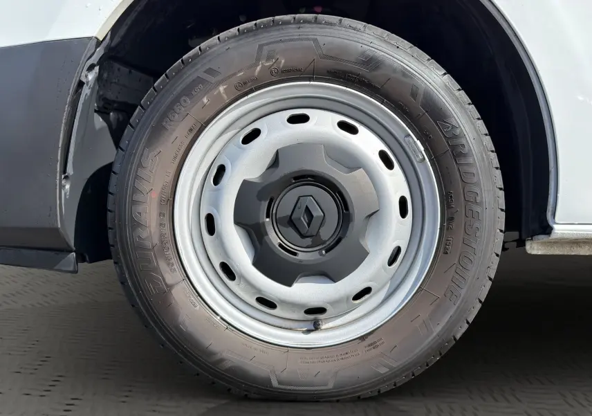 Gros plan sur la roue avant droite blanche d’un Renault Trafic Fourgon 2024 avec jante acier et logo Renault central.