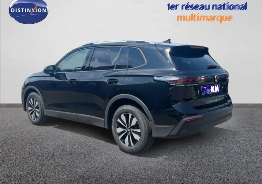 Volkswagen Tiguan noir grenadilla métal en 3/4 arrière droit, avec jantes alliage et toit ouvrant visible.