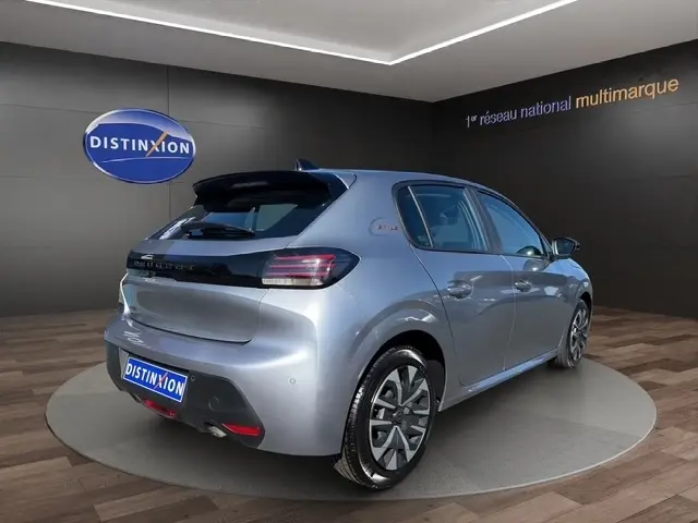 Peugeot 208 100 ch Style gris clair vue 3/4 arrière droit, feux LED et jantes alliage distinctives.