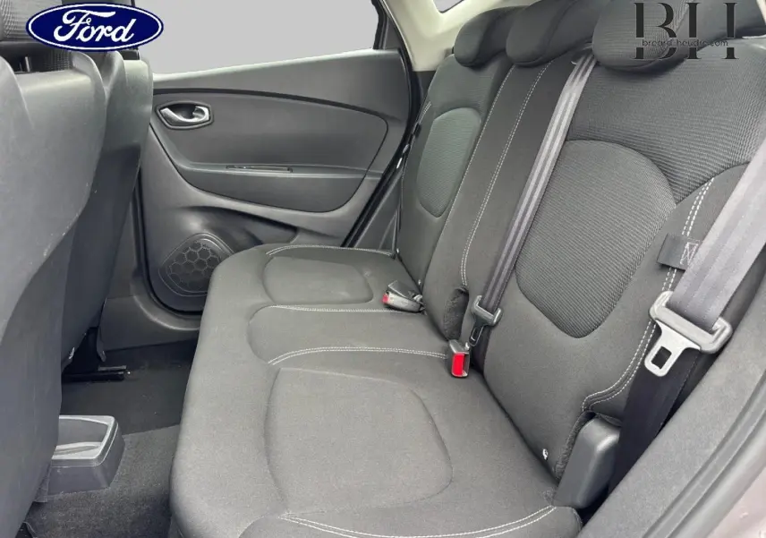 Vue intérieure côté gauche sur la banquette arrière noire avec ceintures de sécurité et porte arrière d'une Renault Captur.