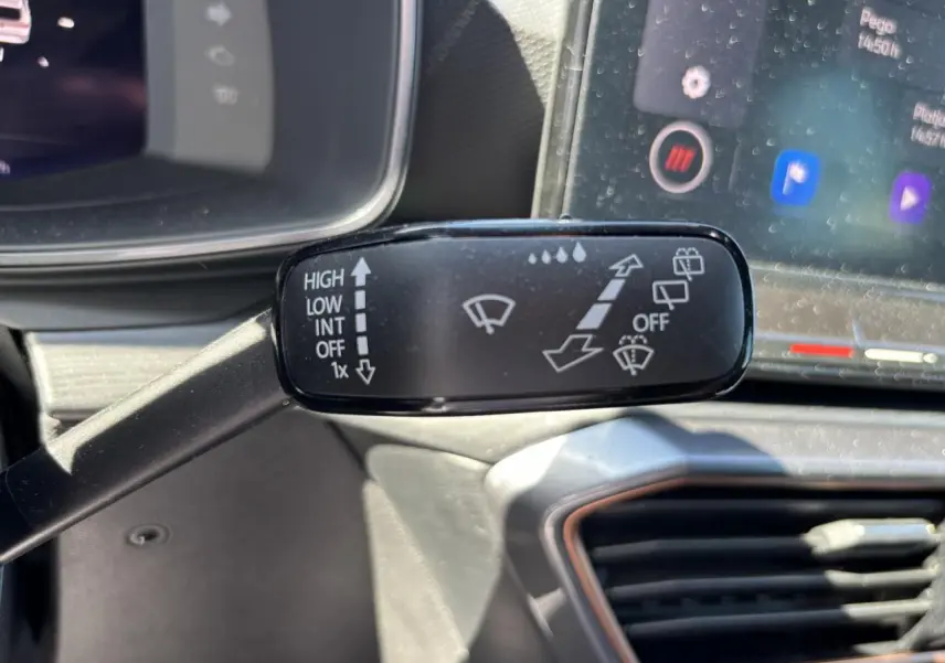 Gros plan sur la commande des essuie-glaces dans l’habitacle du CUPRA Leon Sportstourer 2024, tableau de bord en arrière-plan.