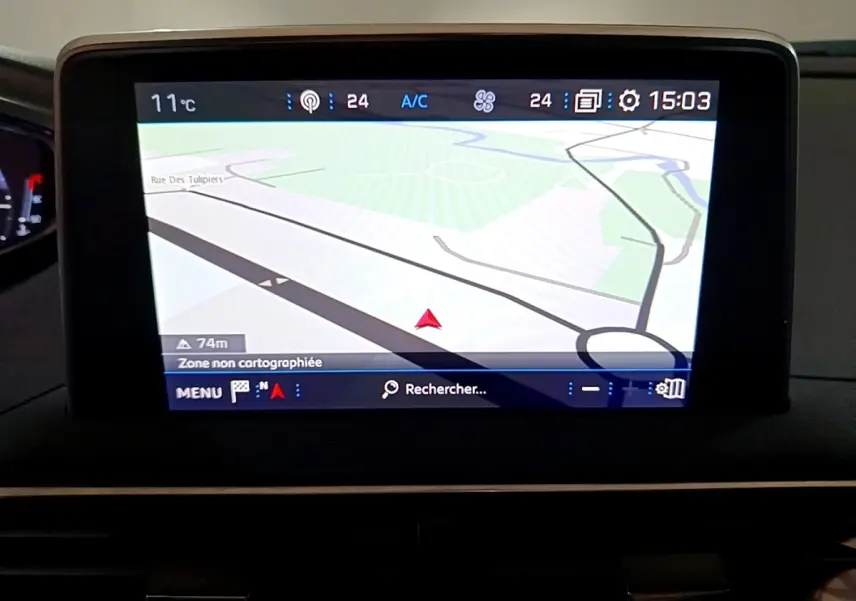 Écran tactile central du tableau de bord du Peugeot 5008 bleu, affichant la navigation GPS en vue 3D.