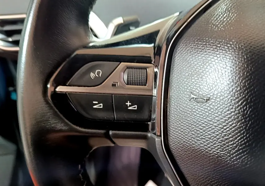 Gros plan sur les commandes gauche du volant cuir noir du Peugeot 5008 bleu, version Allure 2018.
