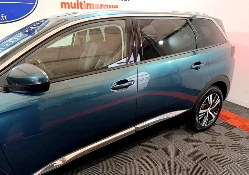 Profil côté gauche du Peugeot 5008 bleu 2018 avec vitres teintées et jantes alliage distinctives.