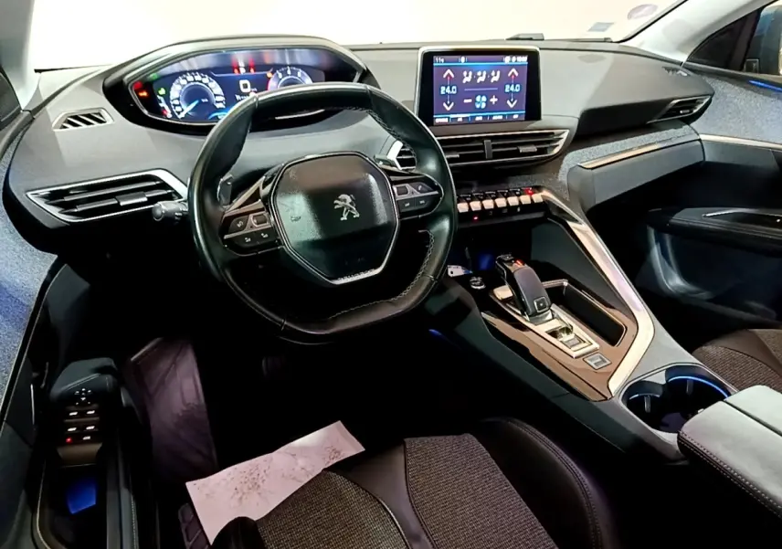 Intérieur Peugeot 5008 bleu 2018 vu côté conducteur, tableau de bord moderne avec écran tactile et volant cuir.
