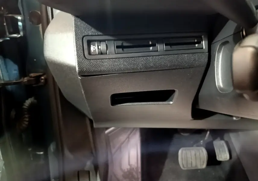 Vue intérieure côté gauche du Peugeot 5008 bleu 2018, montrant la commande des phares et les pédales.