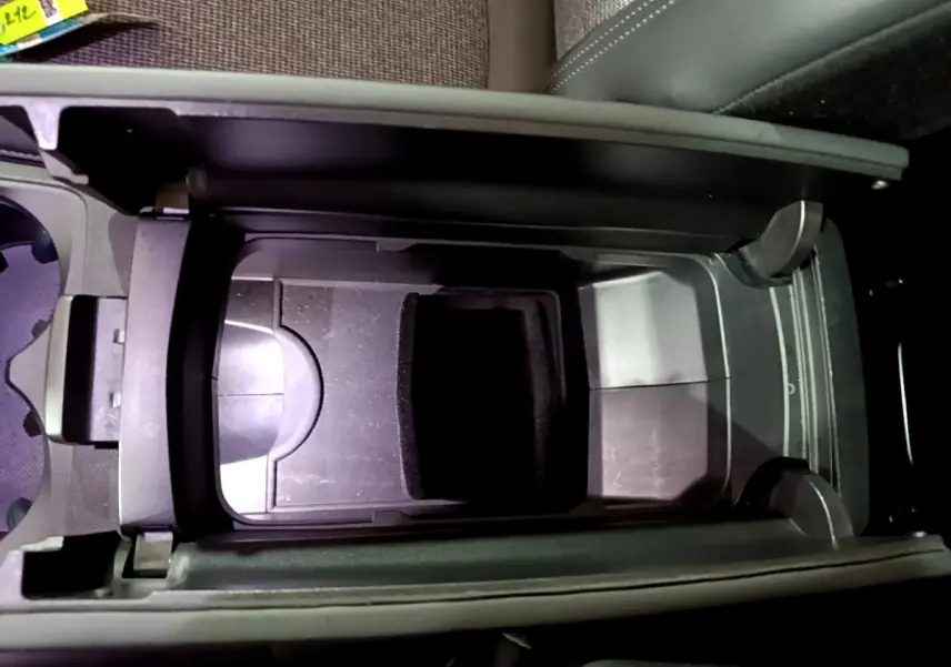 Vue plongeante sur la console centrale noire du Peugeot 5008 Allure 2018 avec rangement ouvert et porte-gobelets.