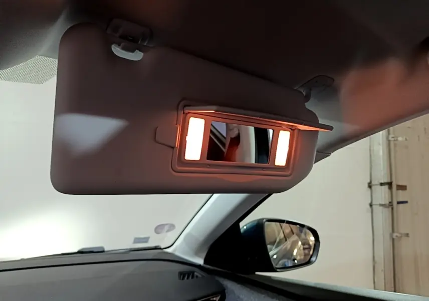 Miroir de courtoisie éclairé sur pare-soleil côté conducteur dans l’habitacle du Peugeot 5008 bleu 2018.