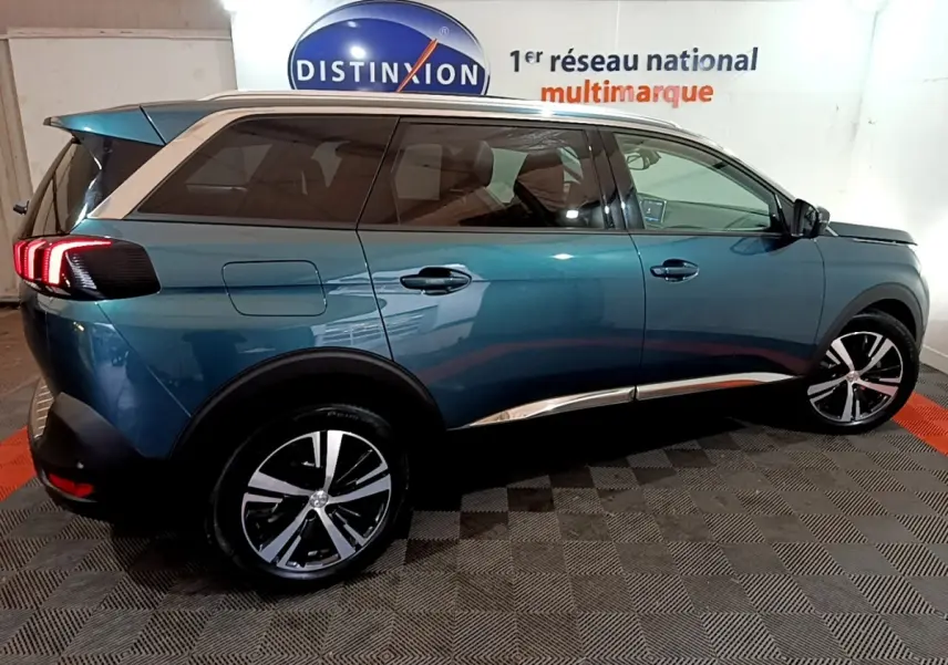 Peugeot 5008 bleu vue de profil côté droit, avec jantes alliage bicolores et toit contrasté blanc.