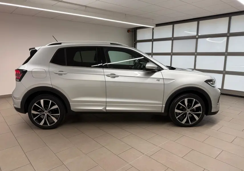 Vue de profil côté gauche d'un Volkswagen T-Cross 1.5 TSI R-Line argent métallisé avec jantes alliage 18 pouces.