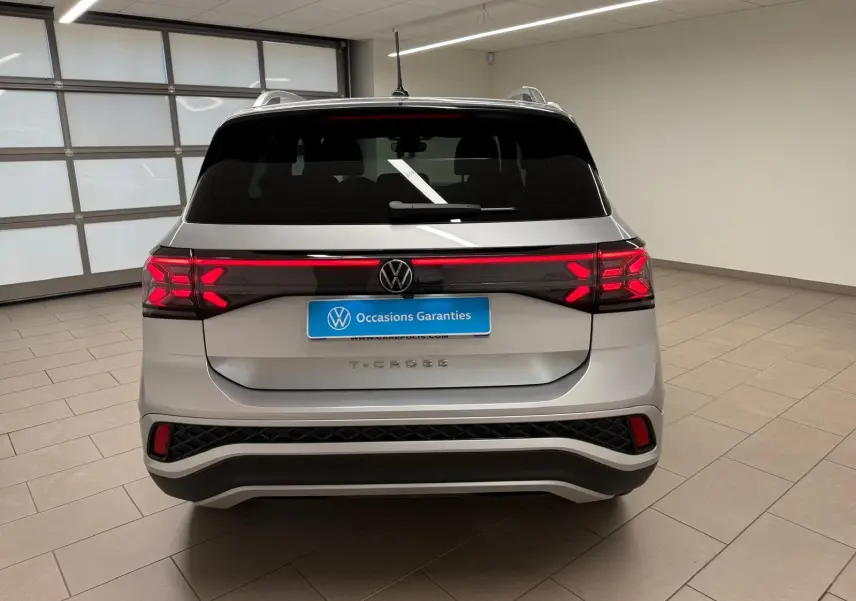 Vue arrière d'un Volkswagen T-Cross 1.5 TSI 150 DSG7 R-Line en couleur Reflet d'Argent avec feux LED allumés.