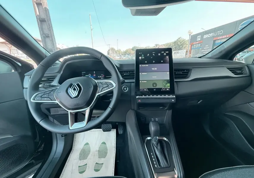 Vue intérieure avant du Renault Captur 2025 noir, avec volant multifonction et écran tactile vertical central.