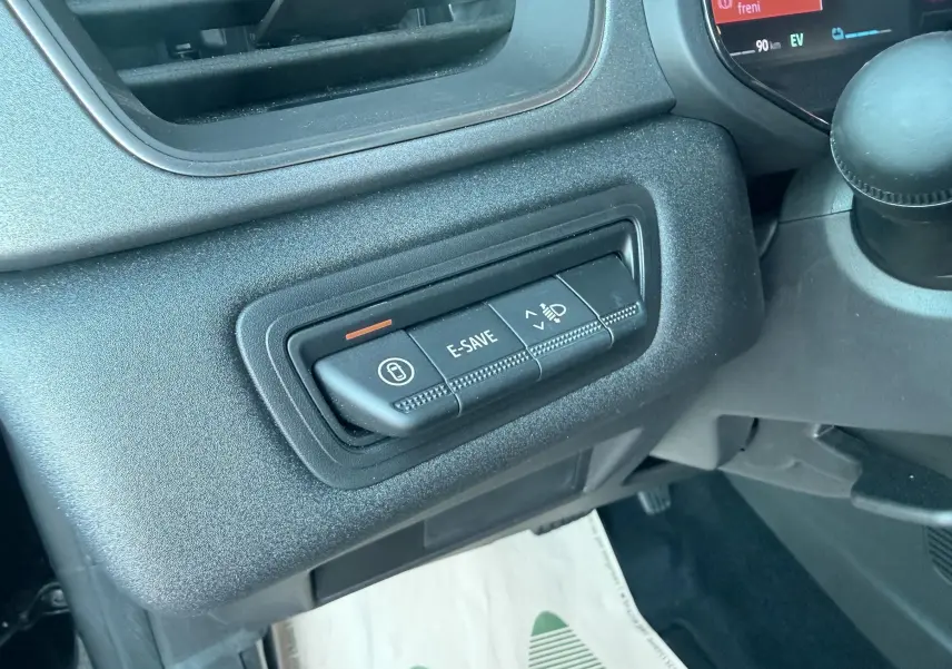Gros plan sur les commandes E-SAVE et réglage des phares du tableau de bord du Renault Captur noir 2025.