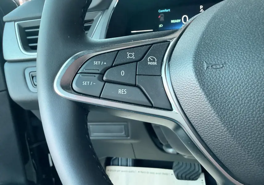 Gros plan sur le volant noir du Renault Captur 2025, montrant les commandes de régulateur de vitesse côté gauche.
