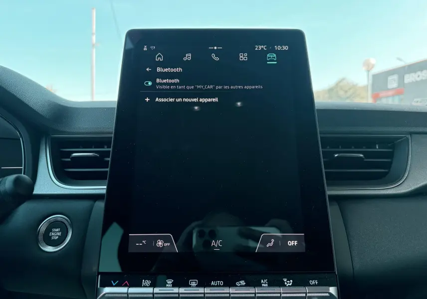 Vue frontale du tableau de bord du Renault Captur 2025, écran tactile central allumé sur menu Bluetooth.