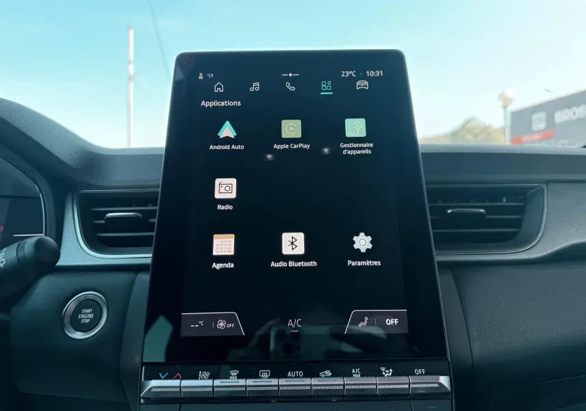 Vue intérieure centrée sur l'écran tactile du tableau de bord du Renault Captur noir, affichant les applications connectées.