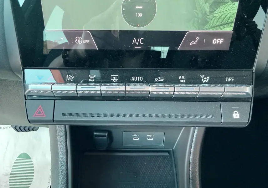 Vue rapprochée du tableau de bord du Renault Captur 2025, montrant les commandes de climatisation et deux ports USB.