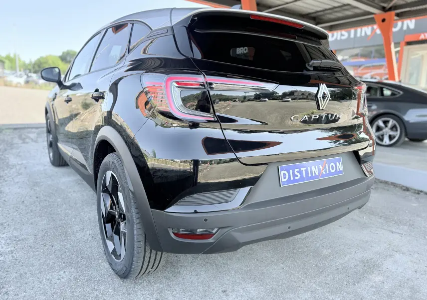 Vue 3/4 arrière gauche d’un Renault Captur noir brillant avec feux arrière LED et jantes noires bicolores.