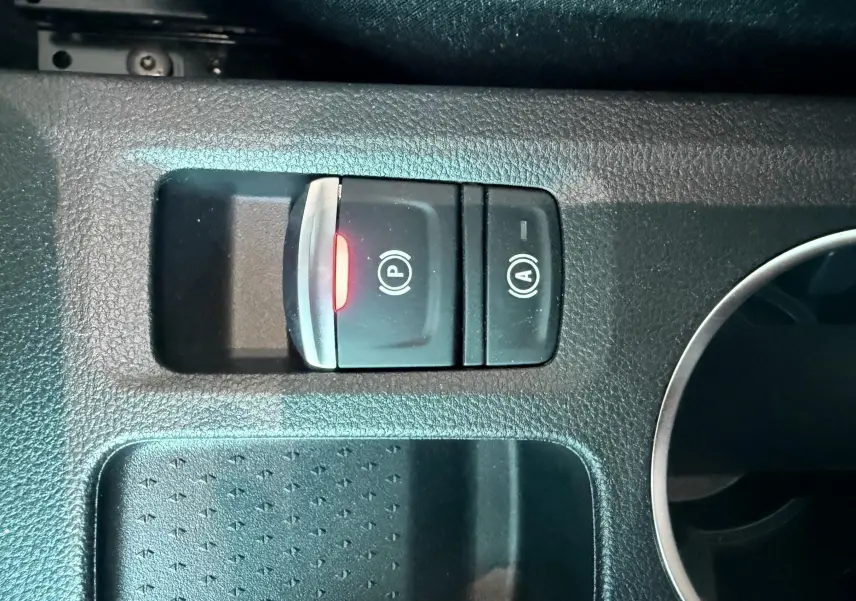 Gros plan sur les commandes de frein à main électronique et arrêt/démarrage automatique dans un Renault Captur noir.