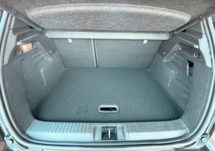 Coffre ouvert vu de l'arrière d'un Renault Captur noir, montrant un espace de chargement propre et vide.