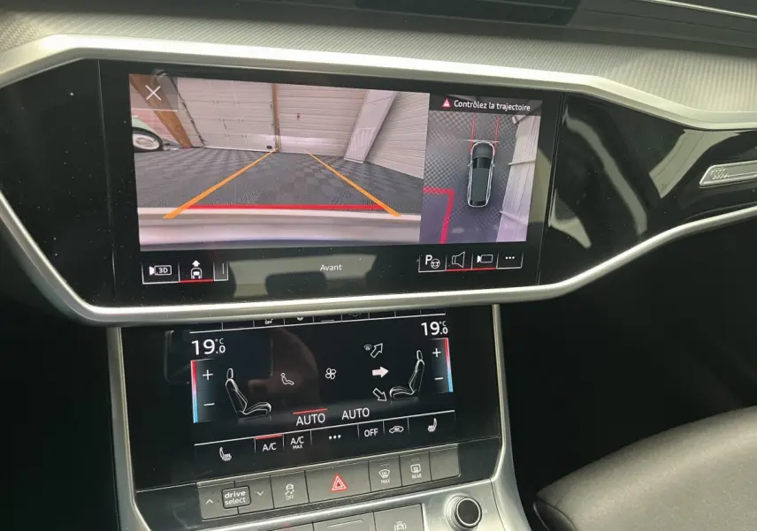 Vue rapprochée de l'écran tactile du tableau de bord d'une Audi A6 noire, affichant la caméra avant et la climatisation digitale.