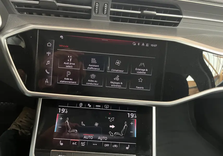 Écran tactile central et commandes de climatisation dans l'habitacle noir d'une Audi A6 40 TDI S Tronic hybrid 2022.