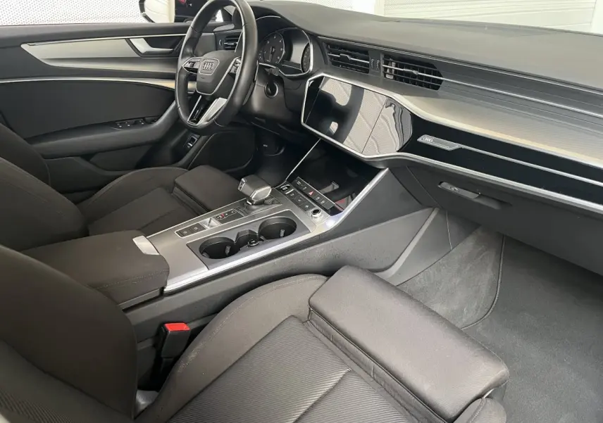 Intérieur noir de l'Audi A6 40 TDI Prestige 2022 vu côté passager, avec tableau de bord moderne et console centrale épurée.