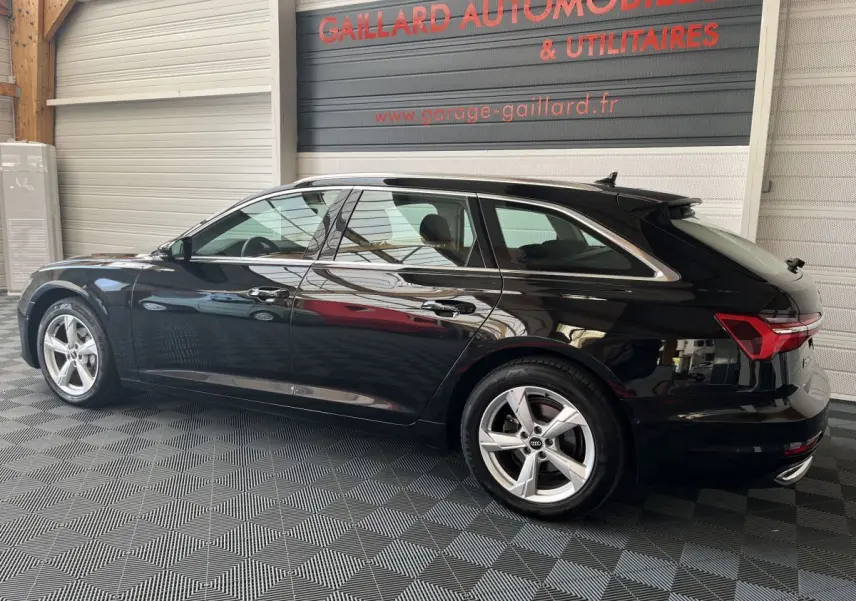 Audi A6 40 TDI S Tronic hybride noire vue de profil côté gauche dans un garage avec sol damier.