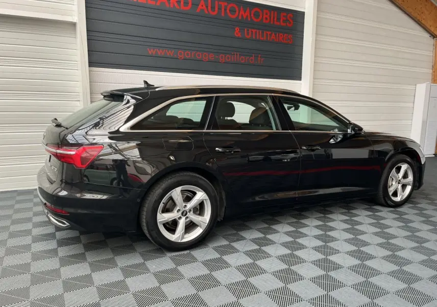 Audi A6 noire vue de profil côté gauche, break élégant avec jantes argentées et feux arrière LED distinctifs.