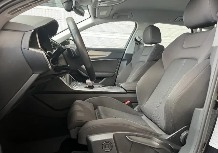 Vue intérieure côté conducteur de l'Audi A6 40 TDI Prestige 2022 avec sièges tissu gris et tableau de bord moderne.