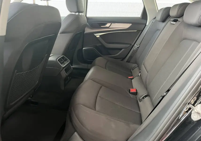 Vue intérieure arrière côté droit de l'Audi A6 noire 40 TDI S Tronic hybrid avec sièges en tissu et aérateurs centraux.