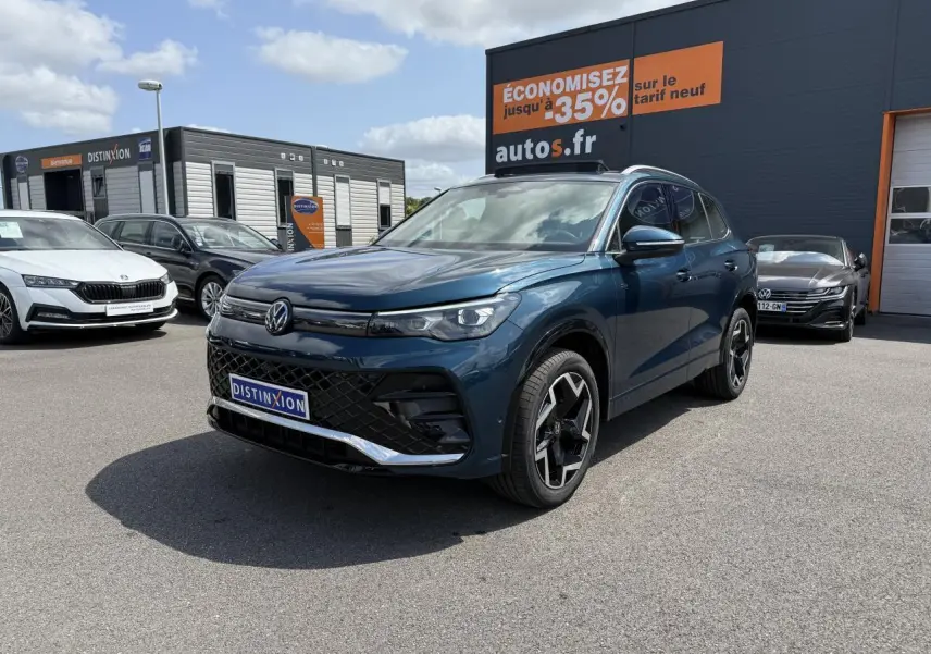 Volkswagen Tiguan 2024 bleu Nightshade en 3/4 avant droit avec jantes R-Line et calandre noire distinctive.