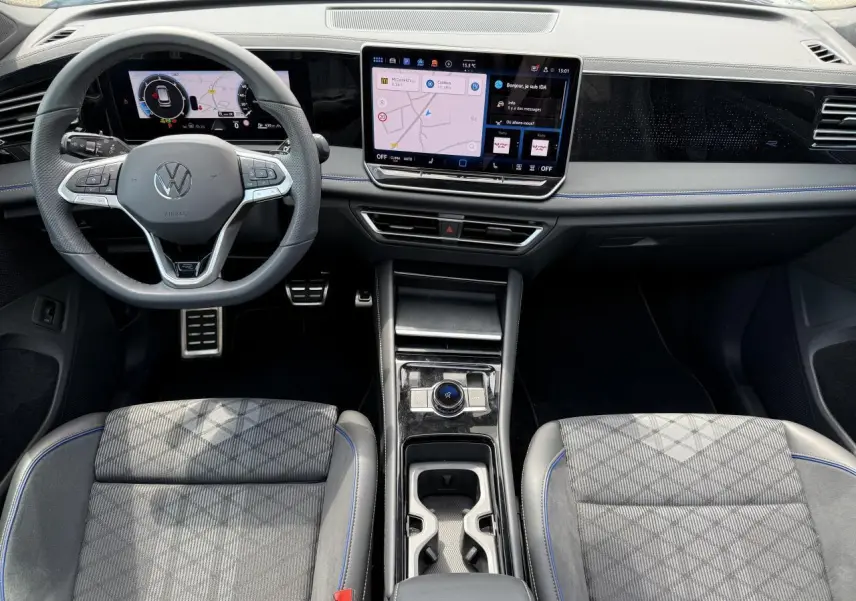 Vue intérieure avant du Volkswagen Tiguan 2024 avec tableau de bord numérique et console centrale moderne.