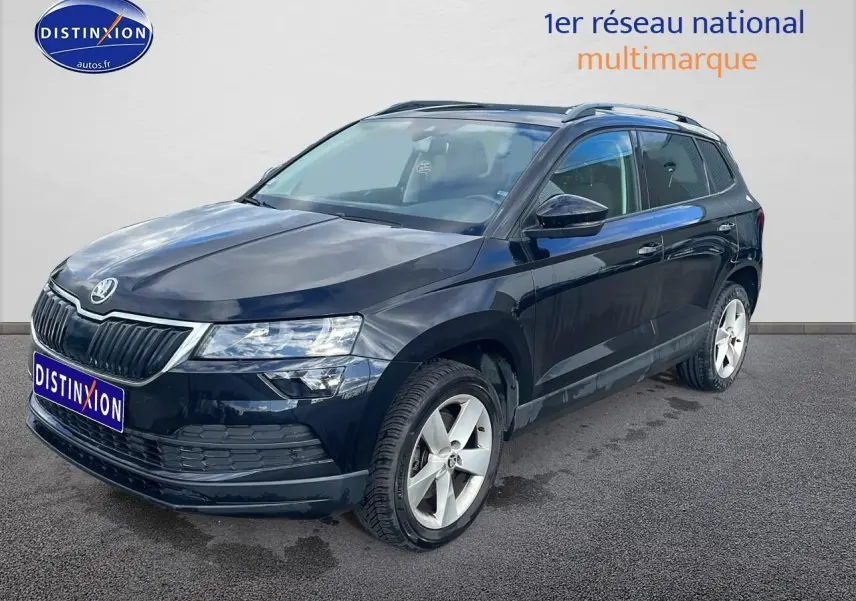 SKODA KAROQ noir vue 3/4 avant droit avec jantes alu et barres de toit sur fond clair.