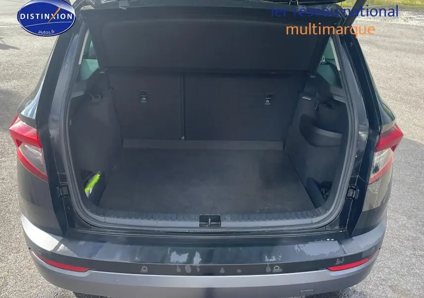 Coffre ouvert vu de l'arrière d'un Skoda Karoq noir 2018 avec hayon électrique et feux arrière LED.