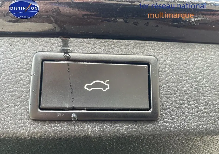 Bouton d'ouverture du hayon noir sur tableau de bord texturé d'un Skoda Karoq 2018 diesel.