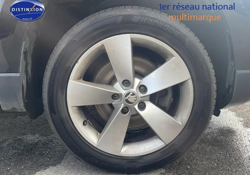 Gros plan sur la roue avant gauche du Skoda Karoq noir 2018 avec jante alliage cinq branches.