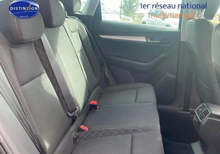 Vue latérale des sièges arrière noirs en tissu du Skoda Karoq 1.6 TDI Business 2018 avec ceintures et aérateurs centraux.
