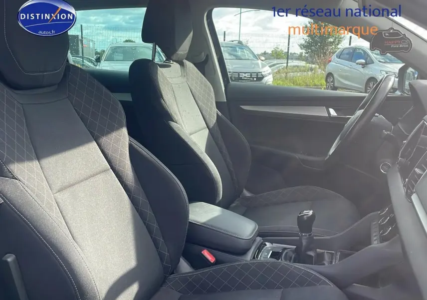 Intérieur avant du Skoda Karoq 1.6 TDI noir, vue côté droit avec sièges tissu et levier de vitesse manuel visible.