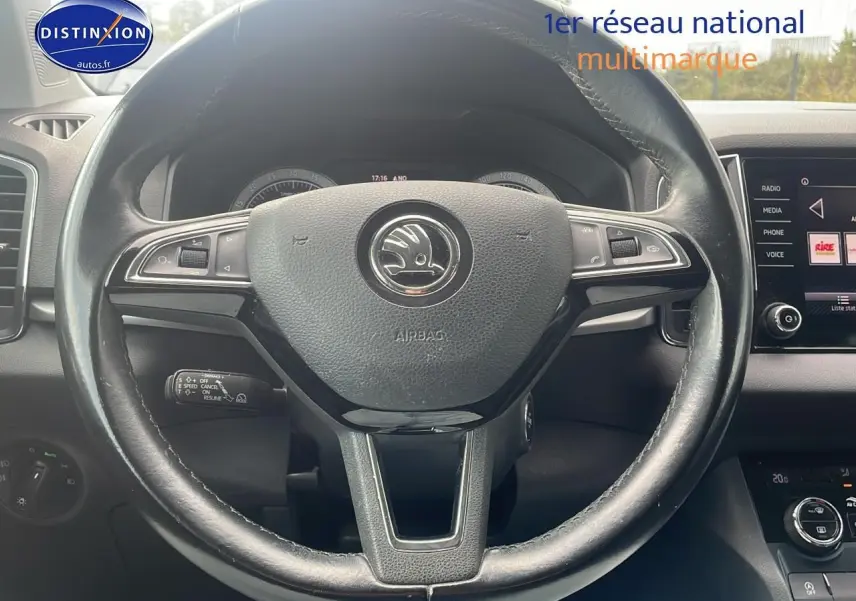 Vue rapprochée du volant cuir multifonction d'une Skoda Karoq 2018 avec tableau de bord et écran tactile visibles.