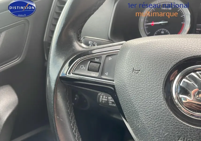 Gros plan sur le volant cuir multifonction noir d'une Skoda Karoq 2018 avec commandes intégrées côté gauche.