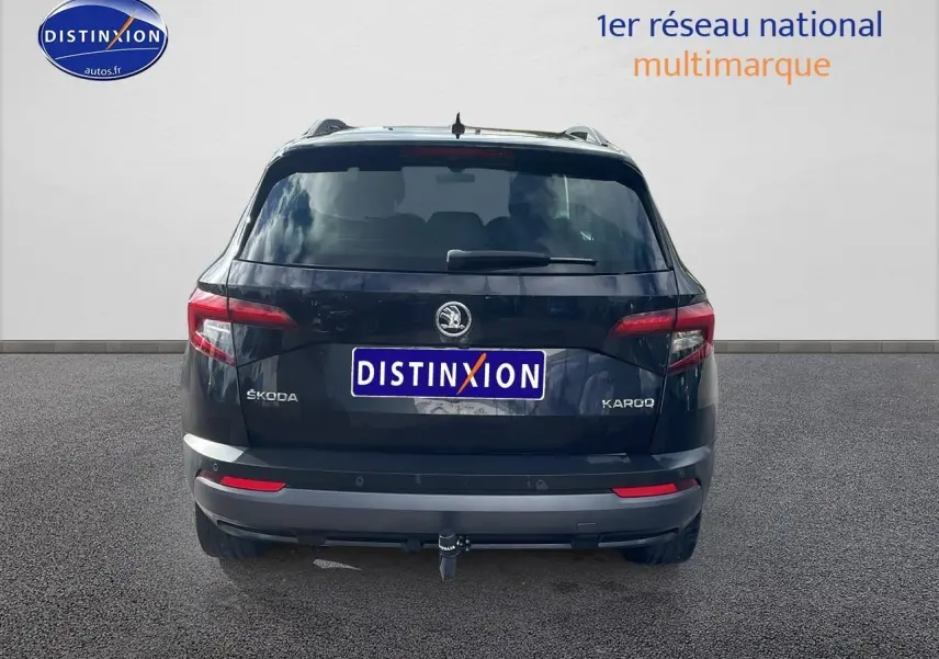 Vue arrière d'un SUV SKODA KAROQ noir avec attelage et feux arrière LED, sur fond neutre.